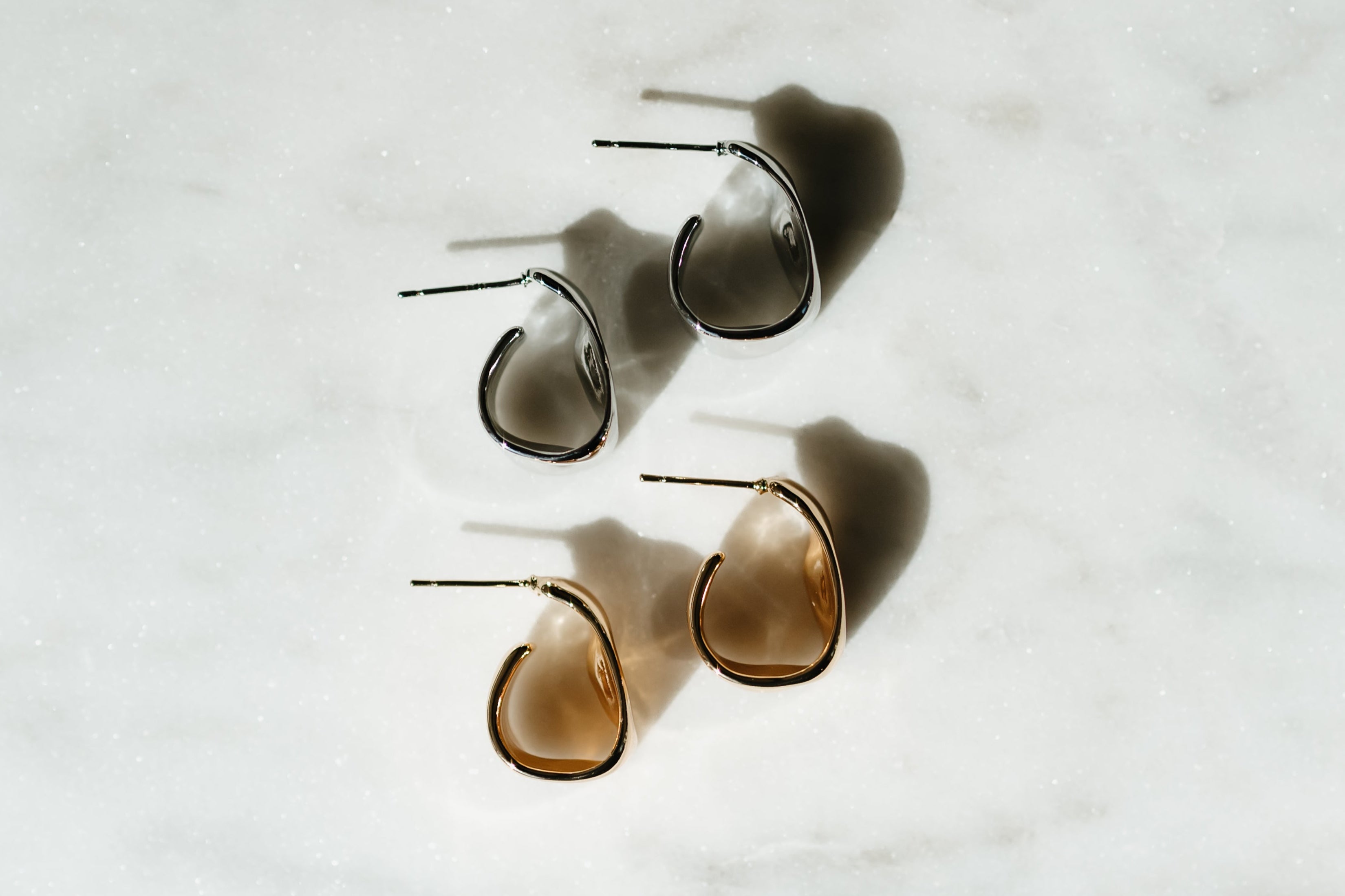 Pair of gold hoop earrings on a light gray background